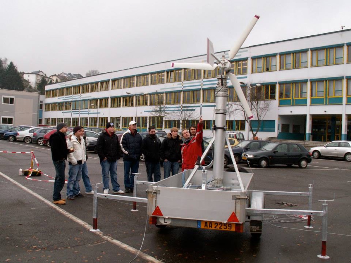 Schülergruppe vor dem mobilen Windrad auf dem Anhänger